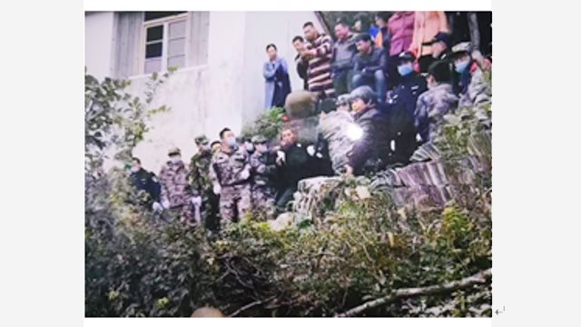 CCP Law enforcement officers dragging an elderly villager who was keeping watch over the temple down the mountain by both hands