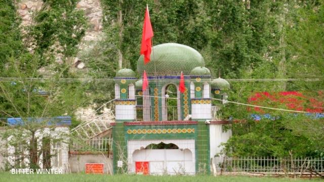 Full view of the Badashi mosque in Kumul. The crescent moons on the domes of the mosque have all disappeared and have been replaced with three Chinese flags.