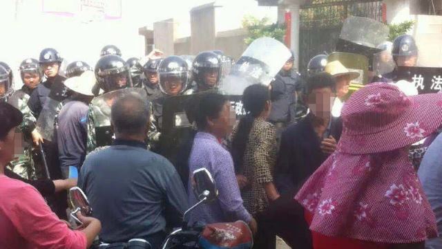 Fully-armed police officers block Christians protesting the demolition