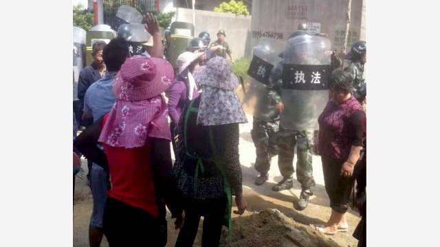 Fully-armed police officers block Christians protesting the demolition