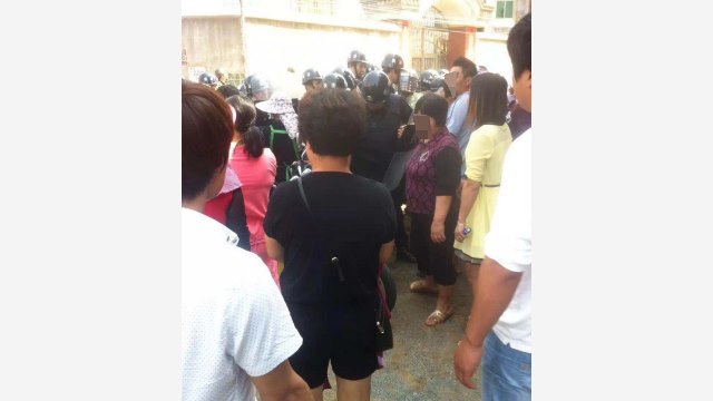 Fully-armed police officers block Christians protesting the demolition.