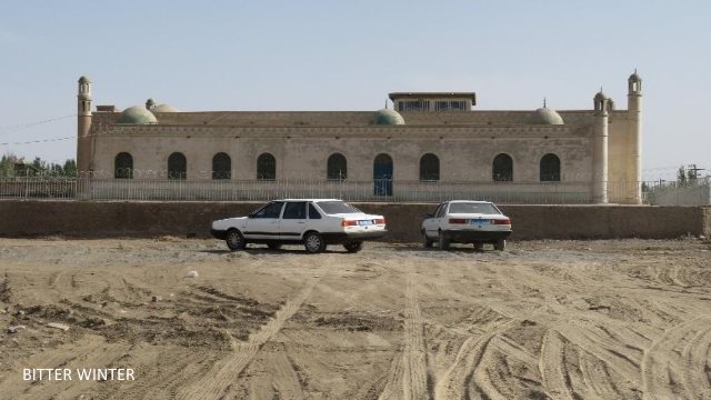 This Jummah mosque is in Shazaojing village of the Huicheng township in Kumul. The crescent moon and star symbols on top of the mosque have all been removed, and tight wire netting has been attached to the surrounding walls. The notice at the entrance reads: “Party members, state officials, and minors not allowed in religious establishments.”