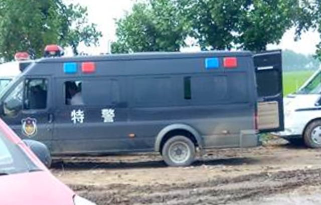 Vehicles from public security and armed police guarding an intersection