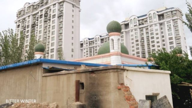 This mosque is located in the Kumul Railway 35th Street Unit, and the authorities have demolished its back walls and locked up all courtyard doors. The crescent moons from the five domes of the mosque have all disappeared.