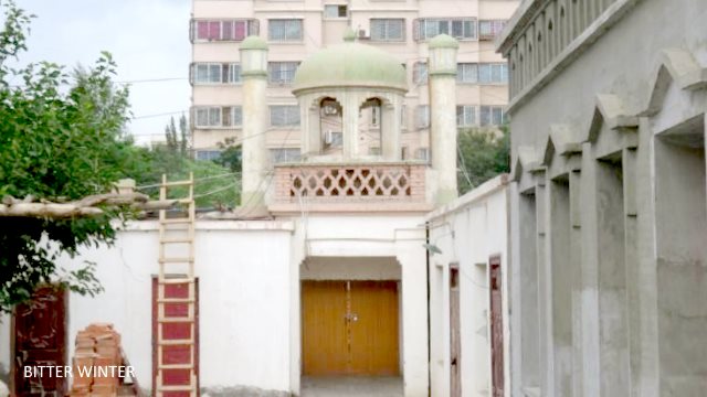 This mosque is located in the Kumul Railway 35th Street Unit, and the authorities have demolished its back walls and locked up all courtyard doors. The crescent moons from the five domes of the mosque have all disappeared.