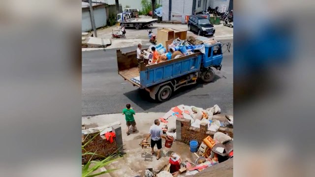 Items from the temple are loaded onto a sanitation truck