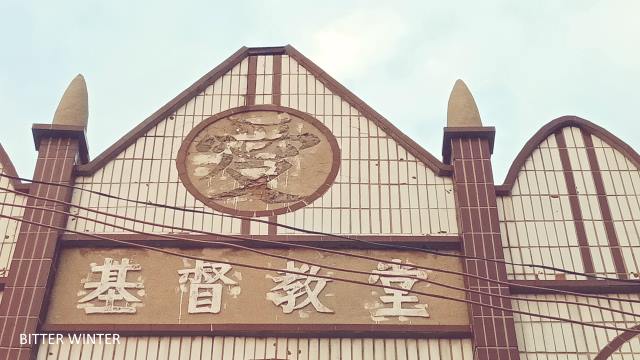 The cross has been removed from the top of the church in the Chencun mining district. The Chinese character “love” beneath the cross has been removed and destroyed.