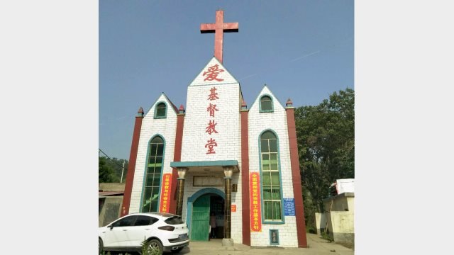 A cross stands atop a Three-Self church in Gongyi city, Henan Province before its removal.