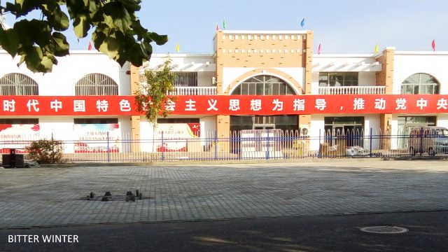 CCP propaganda slogans displayed on the fence of the camp for Uyghur women.