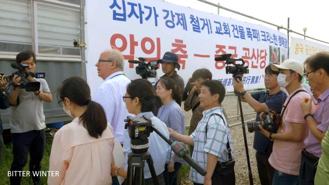 Mr. Zoehrer between demonstrators and journalists