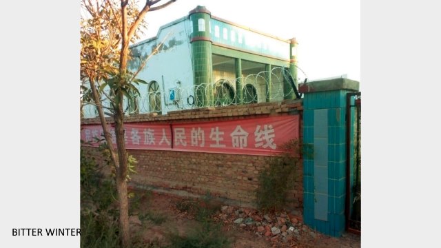 The crescent moon and star symbols at the top of the mosque and the pillars have been demolished. The wall outside the mosque has been fitted with barbed wire to prevent believers from climbing over it to perform namāz (worship).