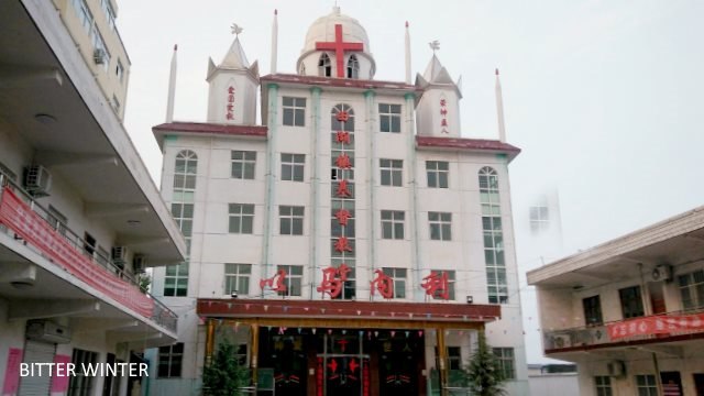 The church’s large cross has been dismantled. A smaller cross, which was forcefully removed from the top of the church, has been moved to the wall near the roof.