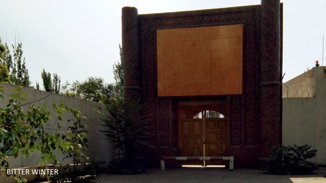 This mosque is located in Qiaoketang village behind the Xinloulan area of Shanshan county; the characteristic Islamic architectural features of the apexes of the mosque have been destroyed, and a large slab of wood is blocking it from the front.