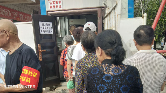Christians enter the church after lining up to have their identification checked by the government security guards responsible for surveillance.