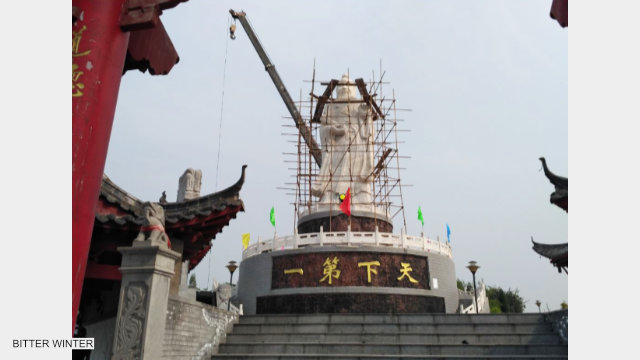 A crane is tearing down the statue