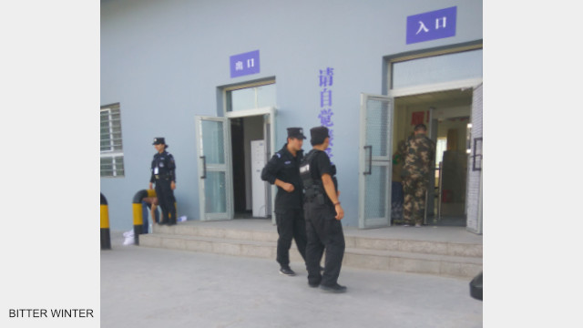 Police patrol and stand guard outside the re-education camp.