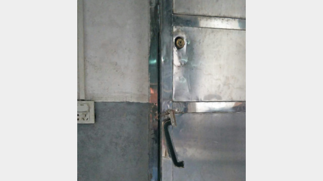 The iron door lock is smashed and broken.