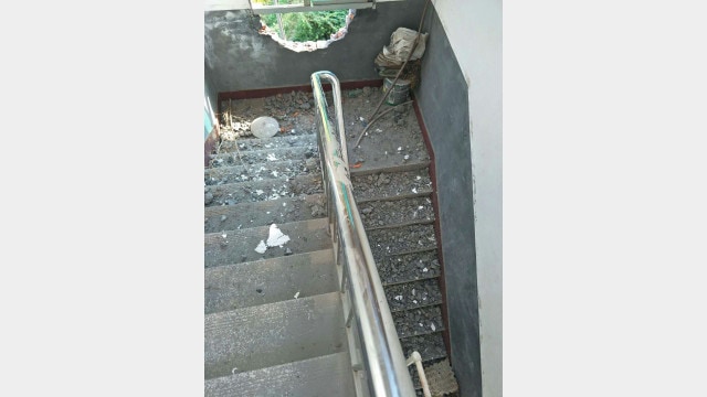 The staircase wall is smashed and destroyed.