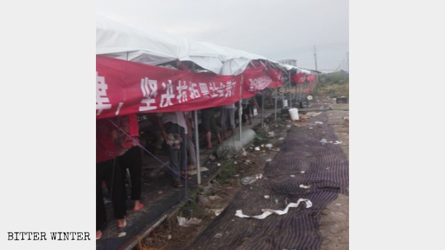 Villagers in their tents guard the farmland
