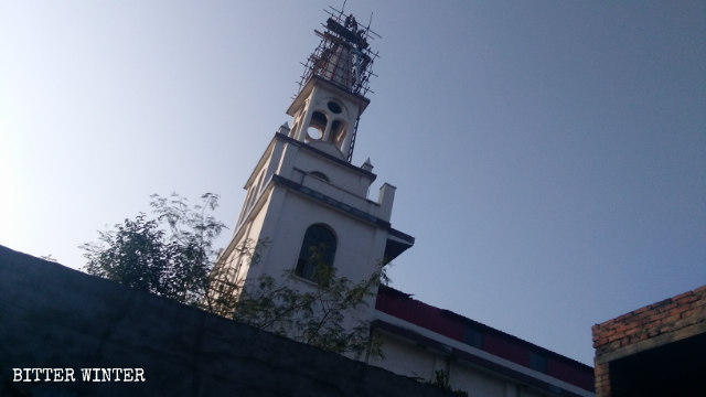 The cross of the church is being demolished.