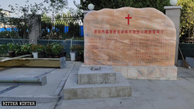 The discarded cross next to the introduction to Three-Self Longhu Urban Wetland Park Church in Xinzheng.