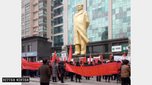 A group gathers under bronze statue