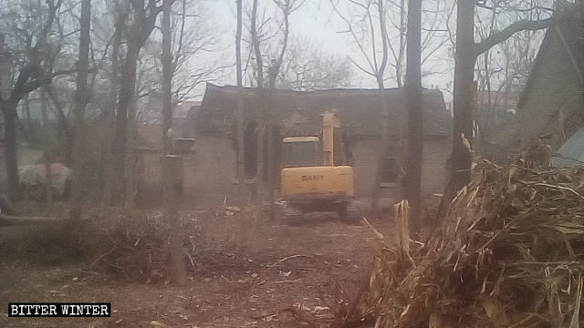An excavator is forcibly demolishing housing