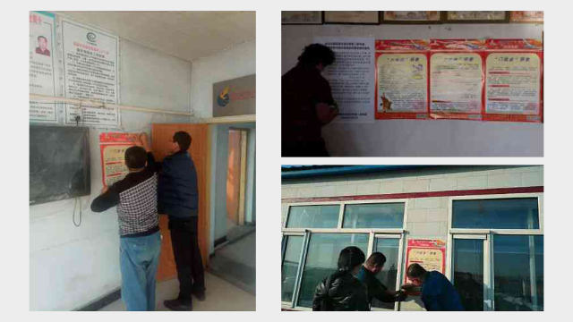 Government employees pasting anti-religion posters on the wall of the village committee office.