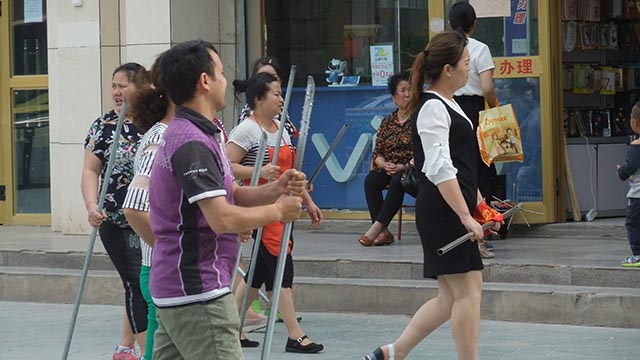 Uyghur community workers carrying medieval pole arms
