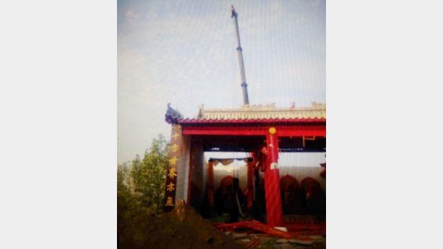 When the hall is being demolished, a crane is lifting the Buddhist statue