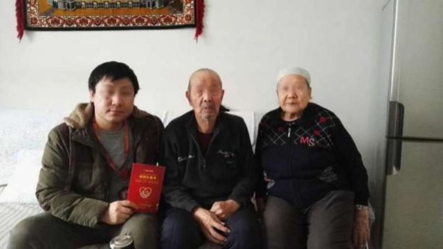 A Han official’s photo with his Uyghur homestay family taken after the signing of “the homestay card”
