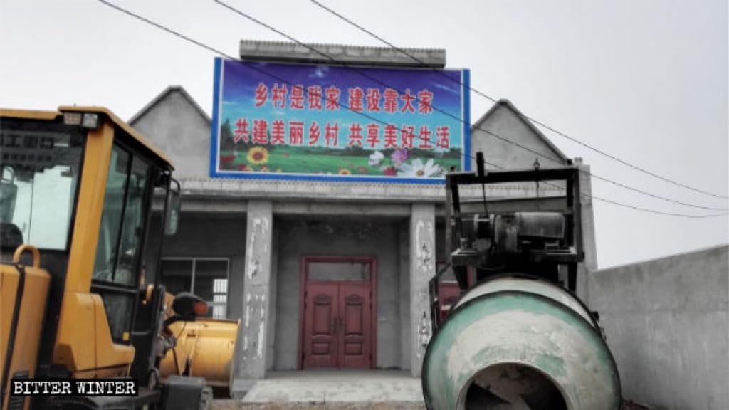 The words “Catholic Church” have been concealed by a signboard reading “The Countryside is My Home.”