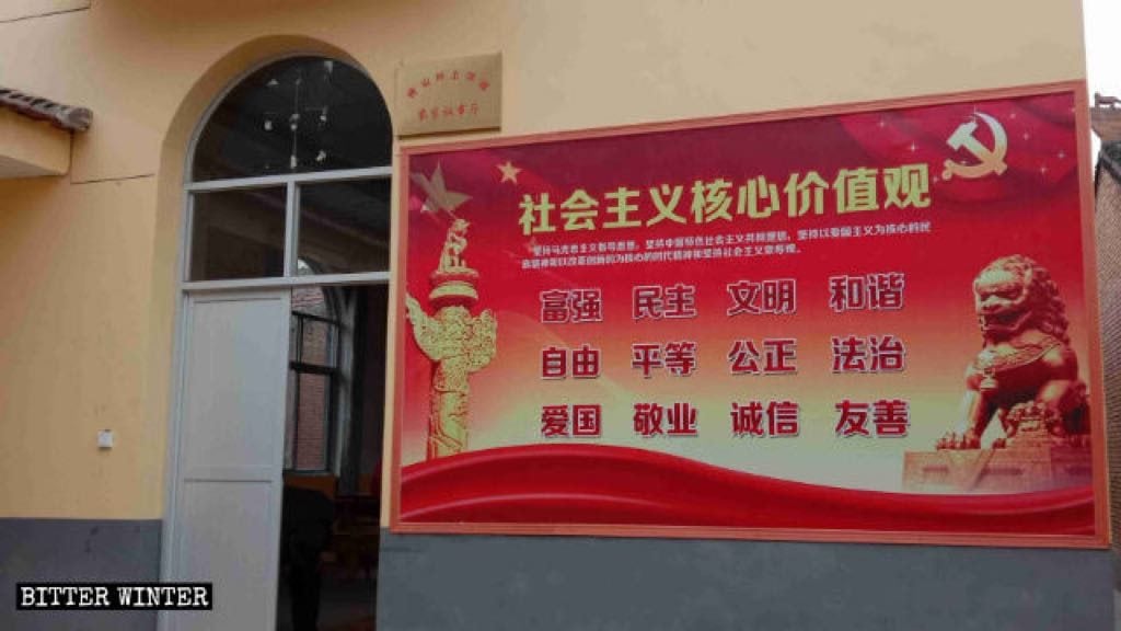The “Farmhouse Council Chamber” sign has been hung up, and a large propaganda poster of the “core socialist values” has been posted on the outer wall.