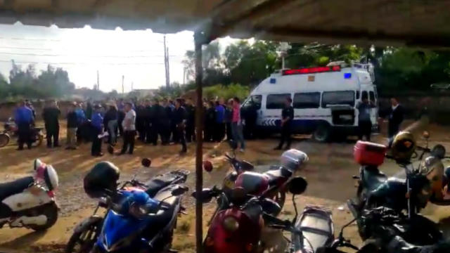 Government personnel gather outside the church in preparation of the forced demolition.