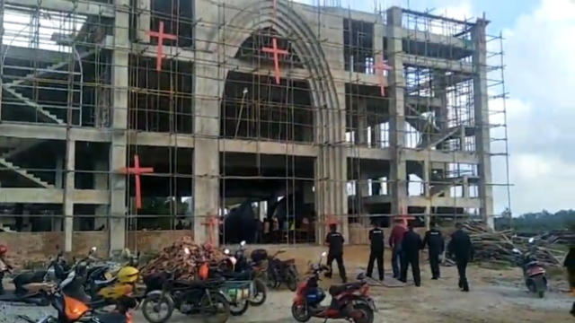 Personnel participating in the forced demolition enter the church.