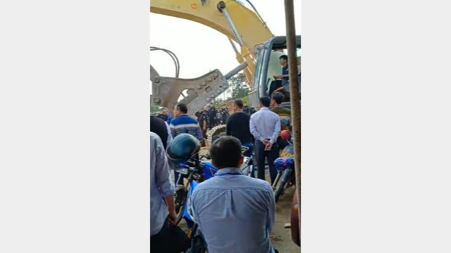 A heavy-duty machine is driven toward the church.