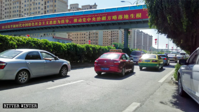 A propaganda slogan poster in Xinjiang’s Urumqi: “Promote the full implementation of the Party Central Committee’s strategy for governing Xinjiang,” guided by Xi Jinping’s thought.