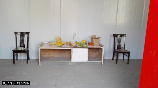 Believers continue to bring offerings and worship in secret, looking at the iron-sheet wall that hides the Buddhist statues.