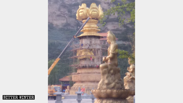 Workers are demolishing Dripping-Water Guanyin statue at Xiaozai Temple.