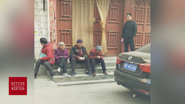Elderly believer praying and crying in front of the closed down church door.