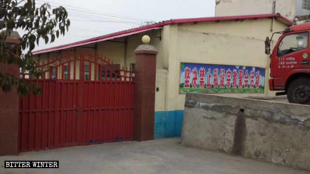 A banner reading “Private religious gatherings and activities firmly prohibited” is posted on the outer wall of the Three-Self meeting venue in Lugou village.