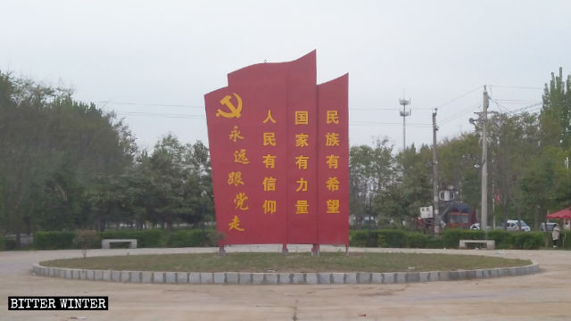 A propaganda sign was put up at the original site of the Quran sculpture.