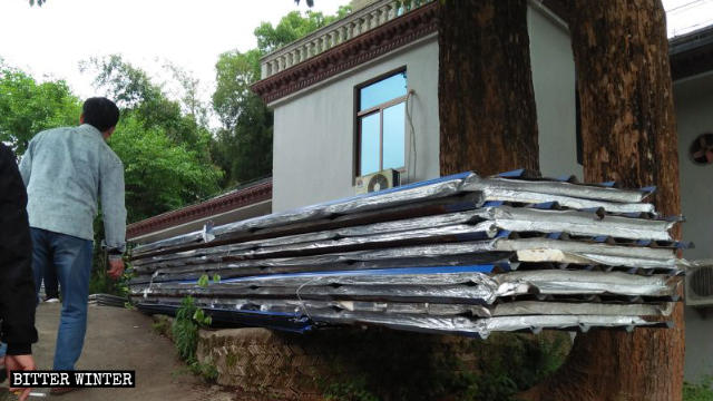 Galvanized iron sheets are placed to the side after being demolished