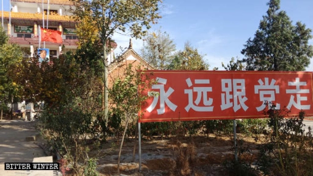 A sign reading “Follow the Party forever” stands in front of Tianyi Temple