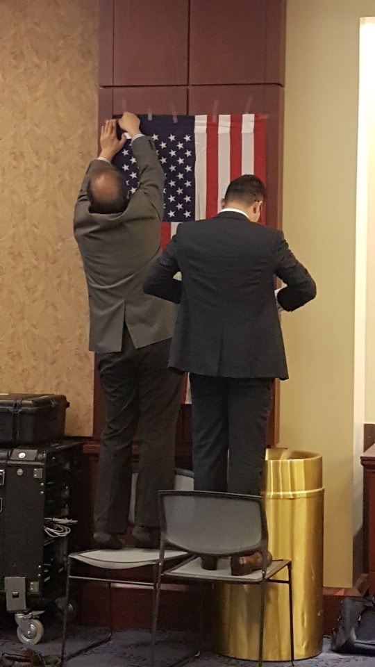 The Uyghurs fixing the US flag to the wall for the opening cerimony in the US Capitol Vistor Center