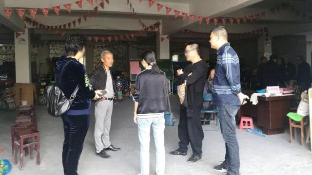 Members of a “team of three” talking to the personnel in charge of a religious venue.