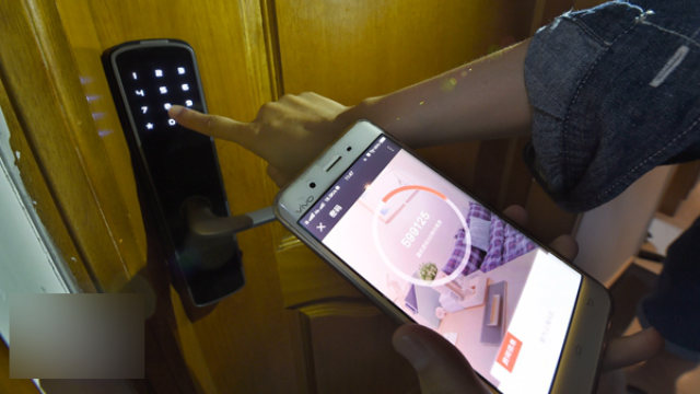 A worker is testing the smart lock with a mobile app.