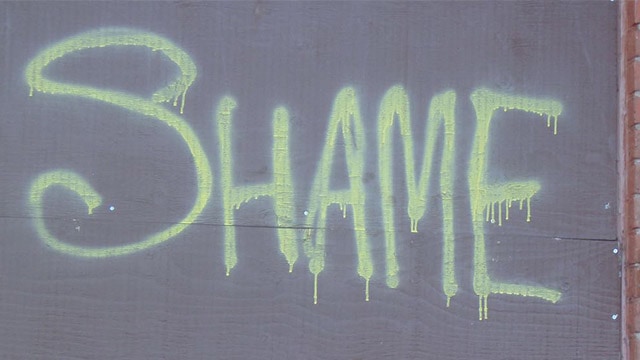 the word "shame" on a wall